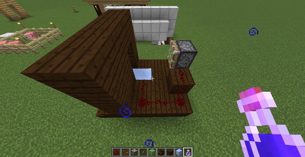 now this is for redstone part! place a redstone dust like that and place a sticky piston 1 block above the floor and 2 blocks away from the ice block you just placed.