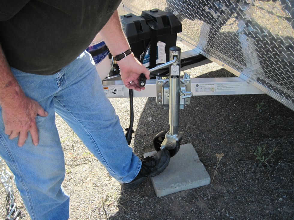 Now time to crank the trailer tongue back down so the weight is now on the tow vehicle. Put your foot next to the wheel so it won't spin around.