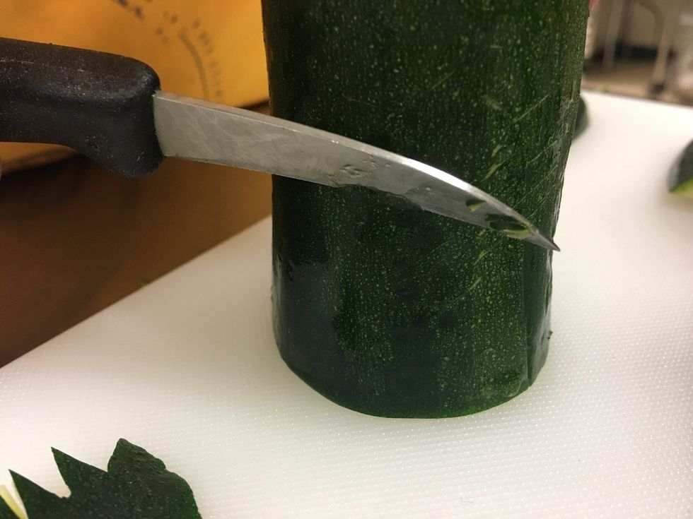 Now to make the tail. GET your MIDDLE piece of Zucchini that you scooted off to the side and use that. Place it up right and cut of a little chunk at the bottom of it.