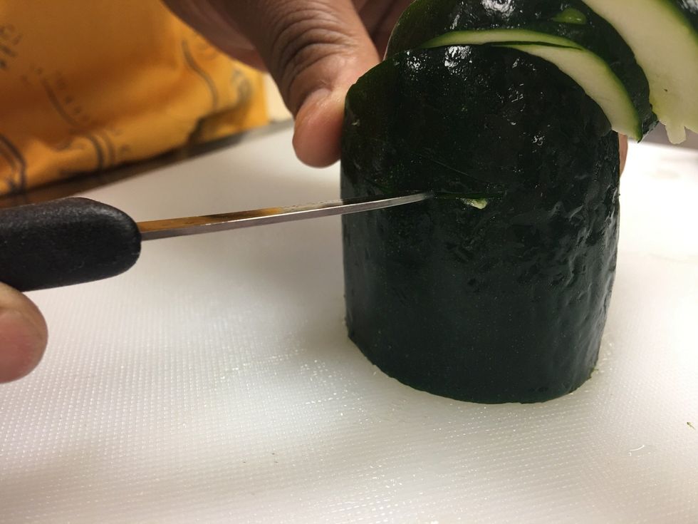 Now to make your wings. Go on the side of your Zucchini in the center and place your knife to cut.