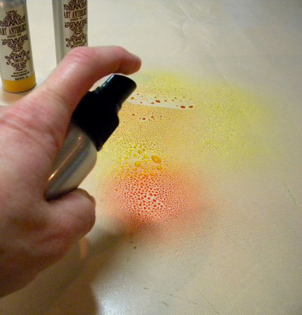 Now to start on the paper for the flowers. To create a marbling effect, spray 2 or 3 similar colors onto the craft mat.