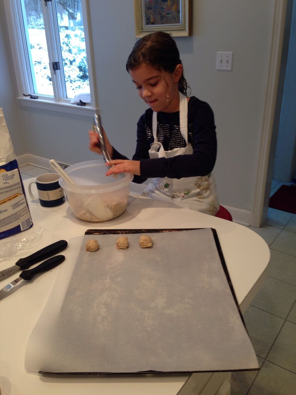 Now to work! Our first cookie is Granny's Russian Tea Cakes. Hildegard is showing you how to use the ice cream scoop. This is the super secret method that pros use to make their cookies identical.