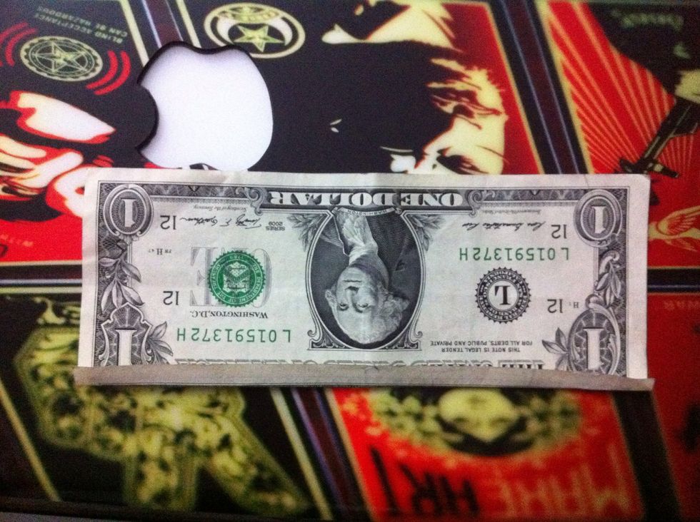 Now turn the bill 180 degrees to your left so that George Washington's head is upside down.