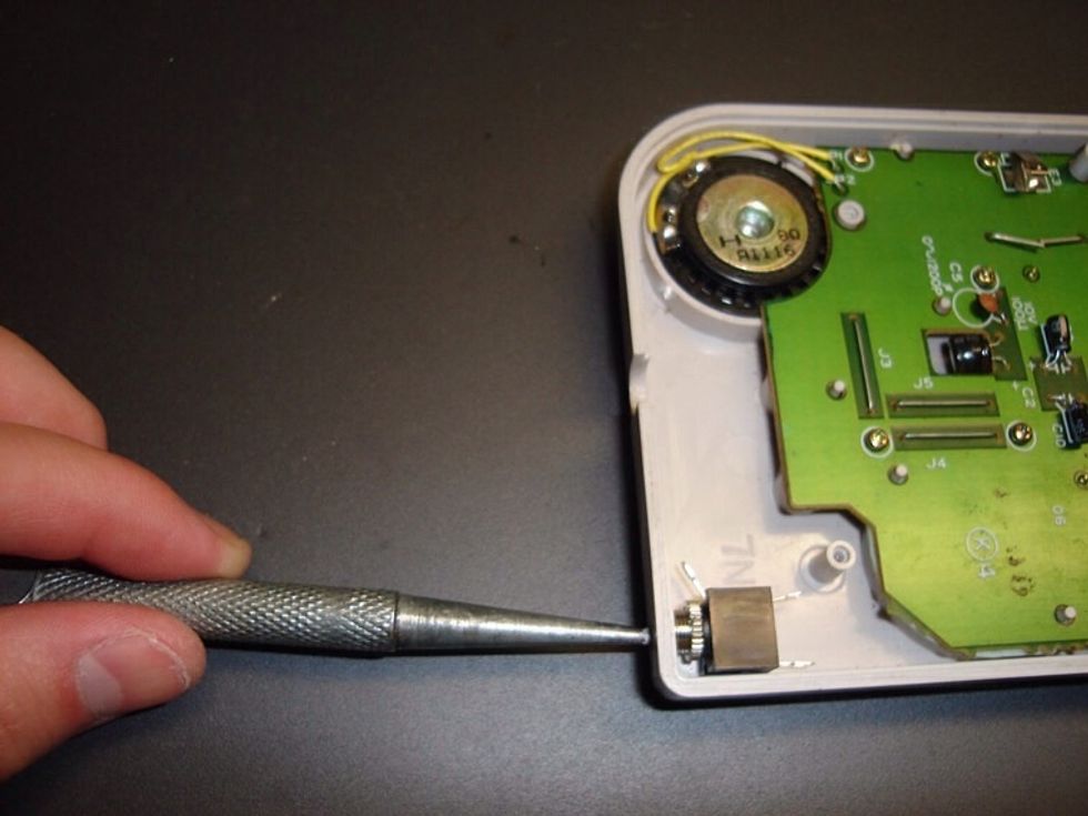 Now use an awl or marker pen to mark where you are going to drill your hole. Press it into the center of the jack, about where the cord will be inserted, until you have a visible mark on the plastic.