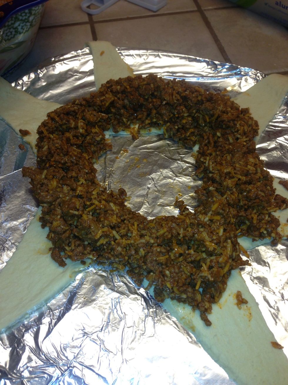 Now using a small spoon spread the meat mixture around the thick part if your crossiant as pictures above. Use your hand to build the mounds of meat around in a circle as you lay it with a spoon.