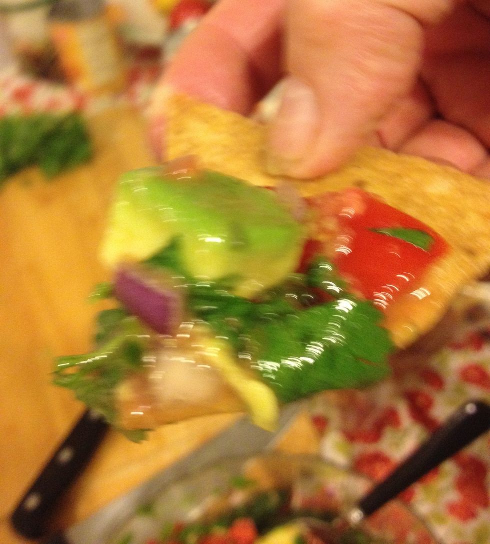 Now, using a tortilla chip from my other guide (on how to make homemade tortilla chips) dip into the salsa and taste test. Oh that's good! (Sorry this picture is out of focus.)