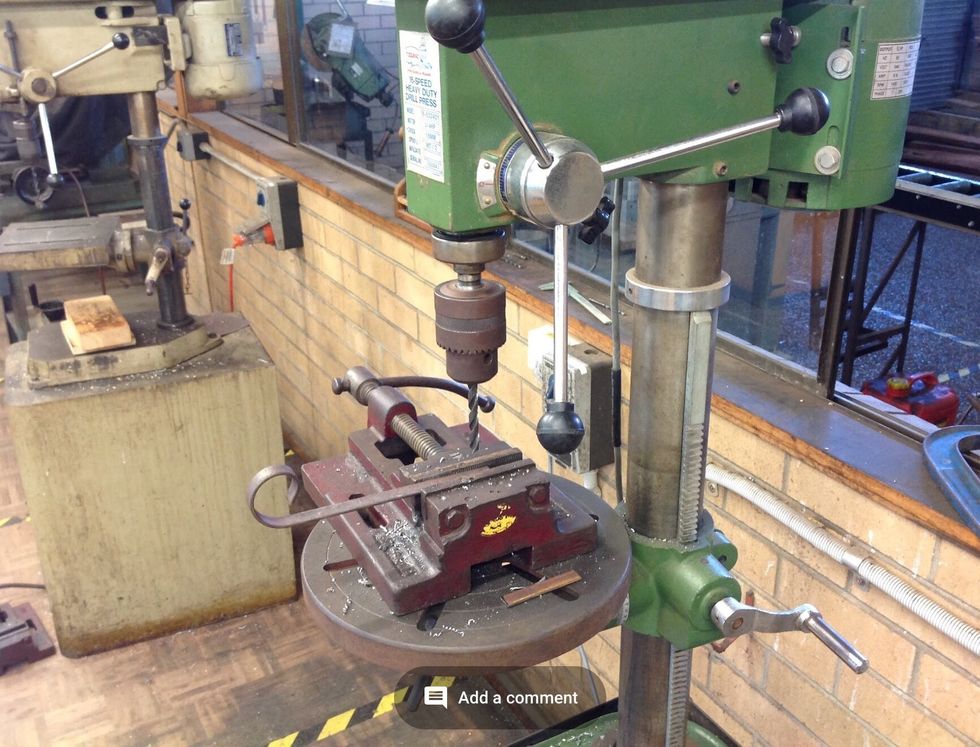 Now using the drill press, align the drill bit up with the indents in the feet and the bar and turn on the drill press. Once turned on apply pressure and drill the holes.