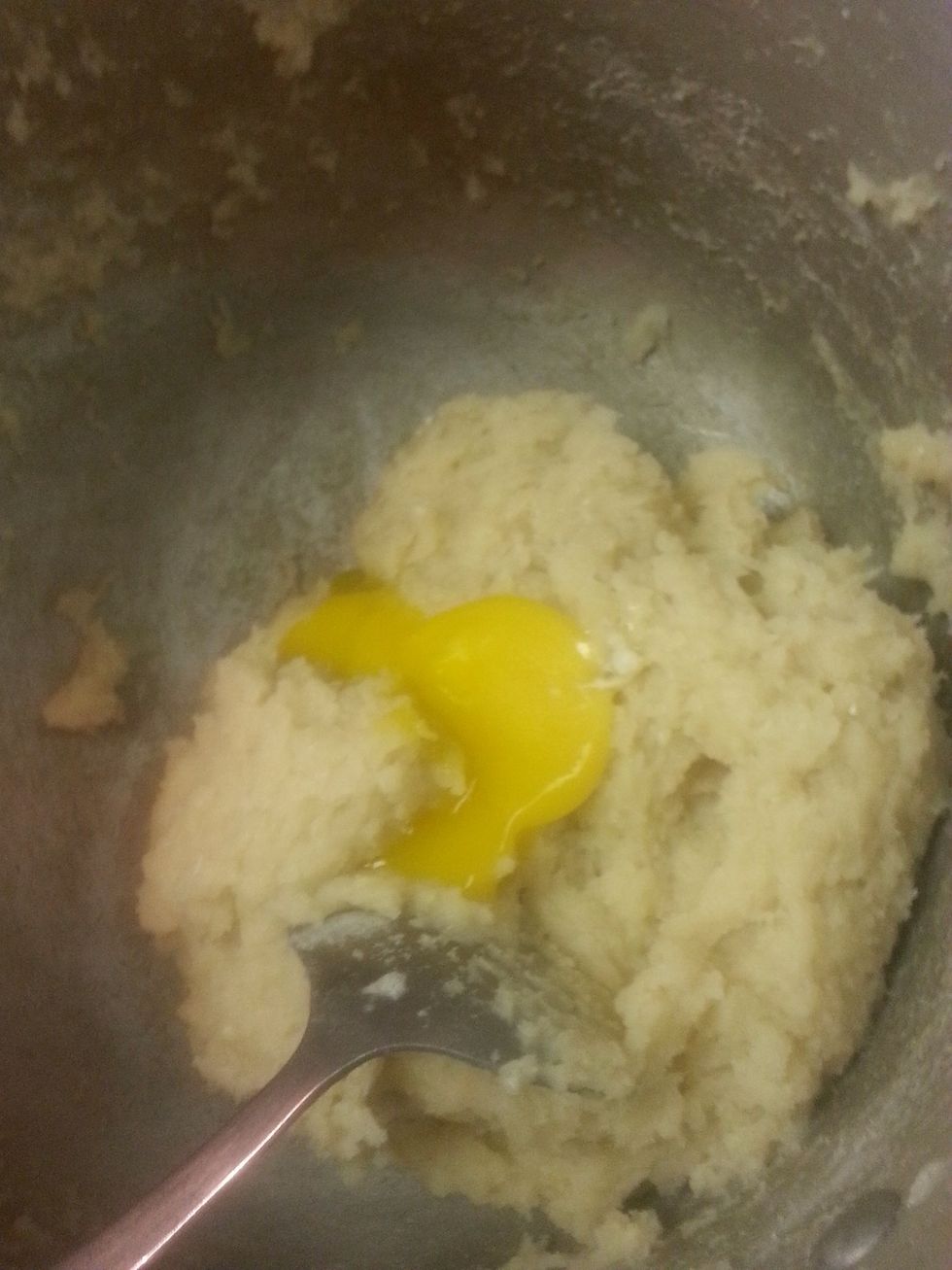 Now we let the dough cool for a little bit just to the touch then we add one egg yolk and mix it in