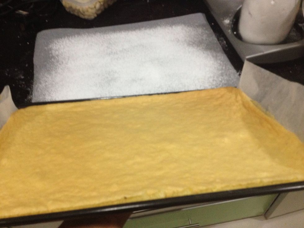 Now we're going to turn over the cake on the sugared paper.