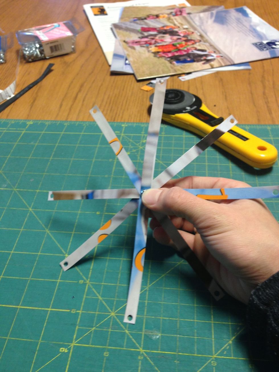 Now we start creating the flower with the strips. First place a bolt through the center hole of your 4 strips, and rotate them so they are evenly spaced.