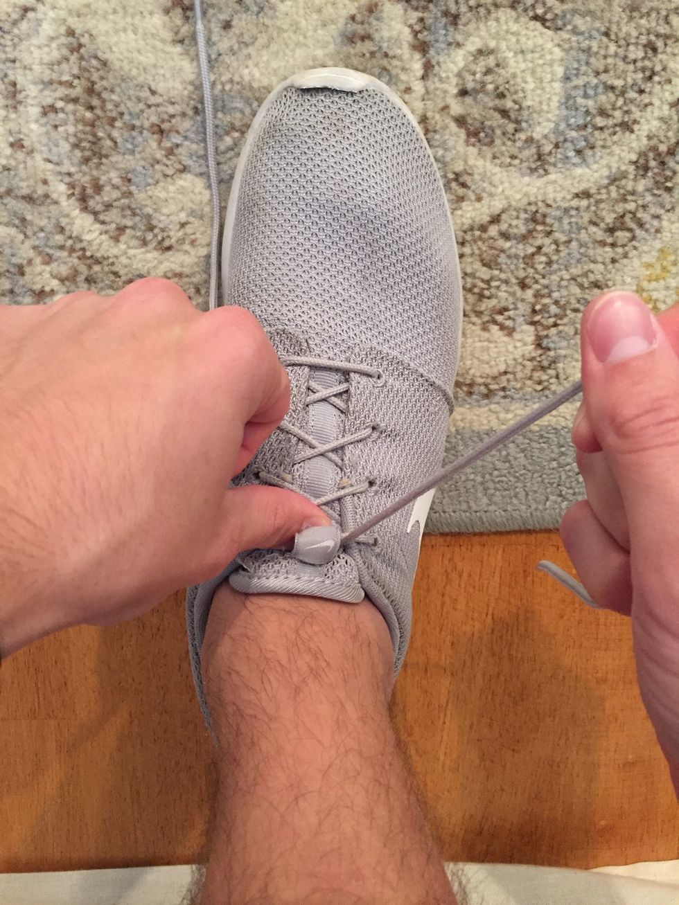 Now, with your right hand, begin to adjust your grip by letting some of the lace through your hands in order to prepare to make the "loop"
