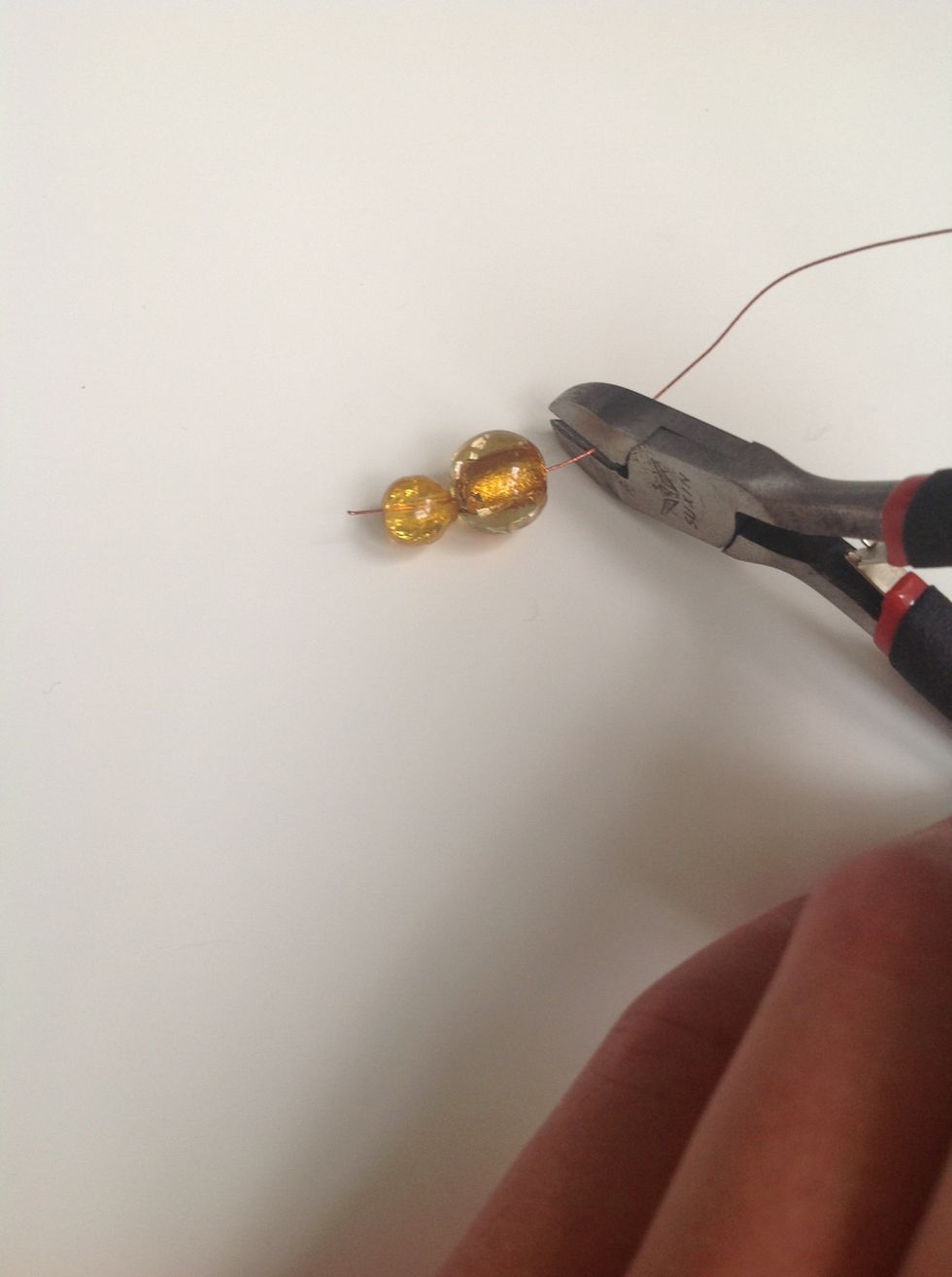 Now you can begin. Take the beads and do like this. Save two ends on either side of the beads.