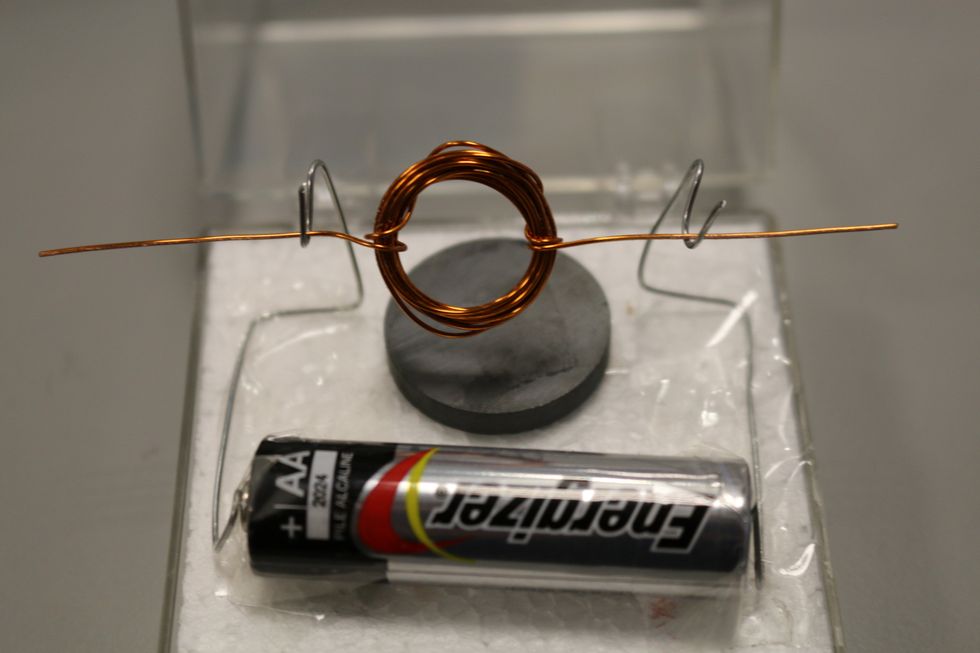 Now you can set your coil down in the hooks. Make adjustments so it is balanced and centered. Its crucial to be sure the two ends of the coil are centered.