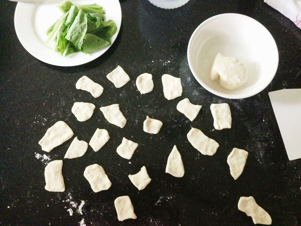 Now you have 2 options: tear off a 1/4 palm-sized amount of dough, flatten and add into broth. Or if you're like me, roll out your dough and shape into squares before cooking in your boiling broth!