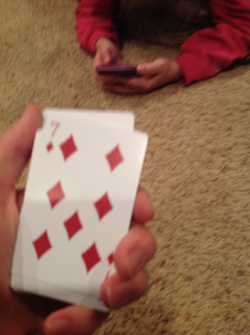Now you have to find their card. Start by turning the deck so the bottom faces you. You should be able to see the number and color of the bottom card.