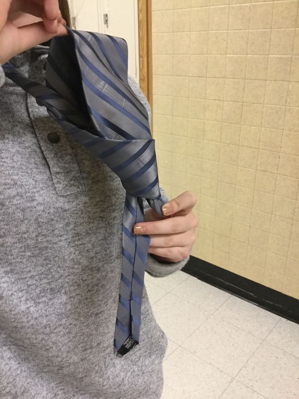 Now, you put the tie through the triangle.