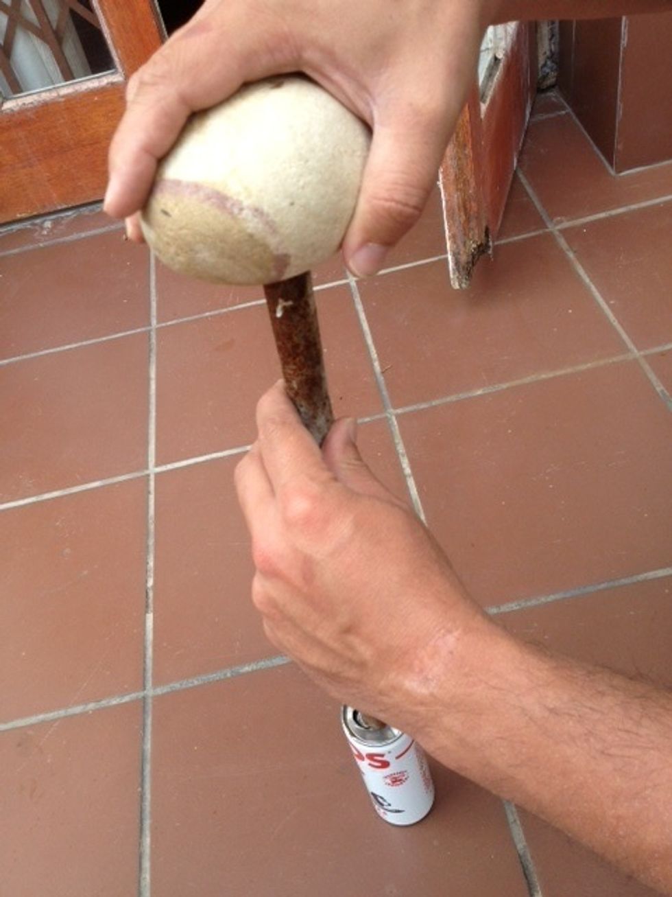 Now you want to remove the top of the can from the body. Use a bit of force to break these pieces apart. You could use a hammer or a rock and a stick.