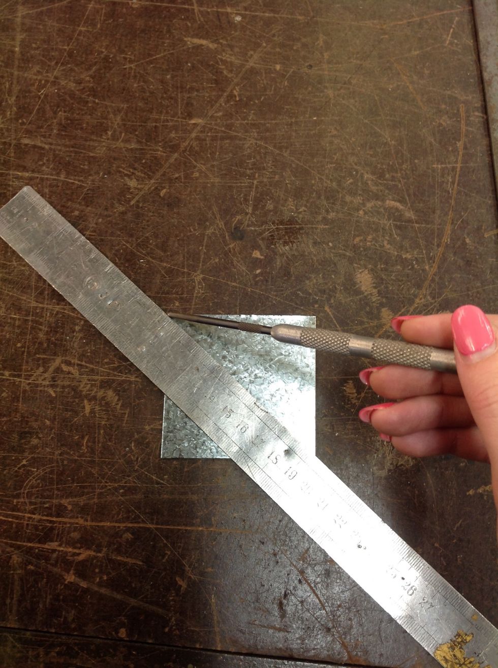 Now, you will have to find where the middle of your square of metal is. You can do this by making an "X" that goes from each corner of the square and marking it with your scriber.