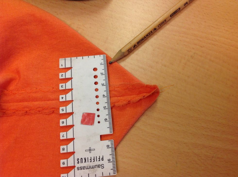 Nu ska du sy av en botten p\u00e5 kassen. L\u00e4gg kassen som bilden visar med s\u00f6mmen mitt p\u00e5 botten. Rita en linje vinkelr\u00e4tt med s\u00f6mmen och sy av s\u00e5 stor botten du vill ha.