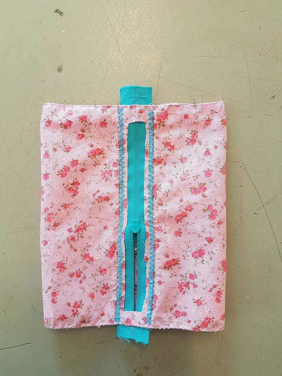 Nu ska du sy ihop botten p\u00e5 tetran. Ha arbetet s\u00e5 att avigsidan \u00e4r ut\u00e5t och l\u00e4gg det s\u00e5 att du f\u00e5r dragkedjan i mitten. Tv\u00e4rn\u00e5la med knappn\u00e5lar.