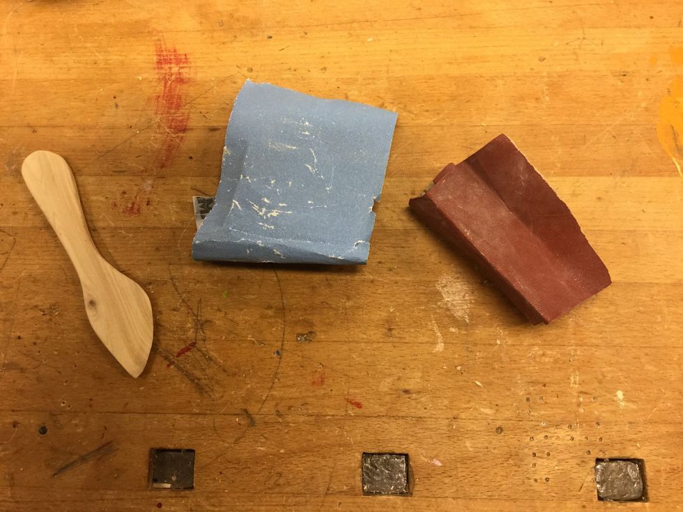 Nu \u00e4r det bara finslipningen kvar. B\u00f6rja med sandpapper P100 och slipa av kniven med, slipa runt om, in i alla skrymslen och \u00f6ver hela kniven. G\u00f6r sedan likadant med P150.