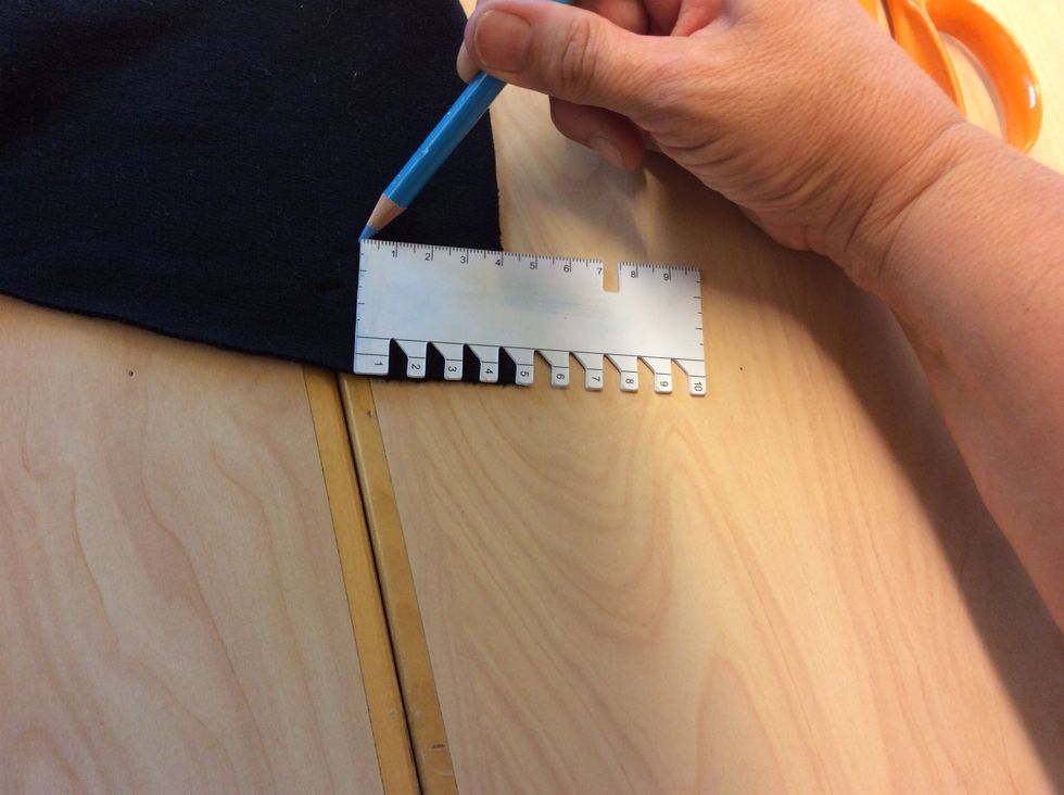 Nu \u00e4r det dags att markera knapph\u00e5len till bandet p\u00e5 luvan. M\u00e4t in 4 cm p\u00e5 b\u00e5da sidorna av luvans nederkant och s\u00e4tt en markering med tygpenna.