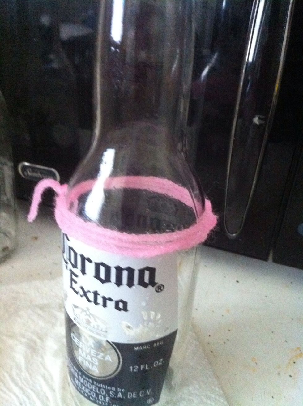 Okay, now put the soaked yarn in the beer bottle, and make sure to make it evenly placed on there.