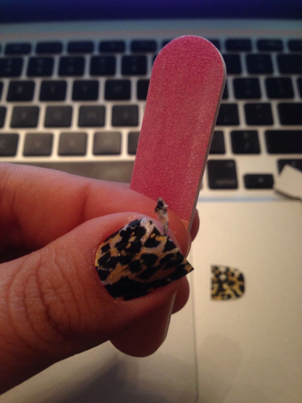 Okay, now using the rough pink part of your file, gently file down any excess. Be sure to hold the file vertically and not on an angle so you're not filing off the strip!!