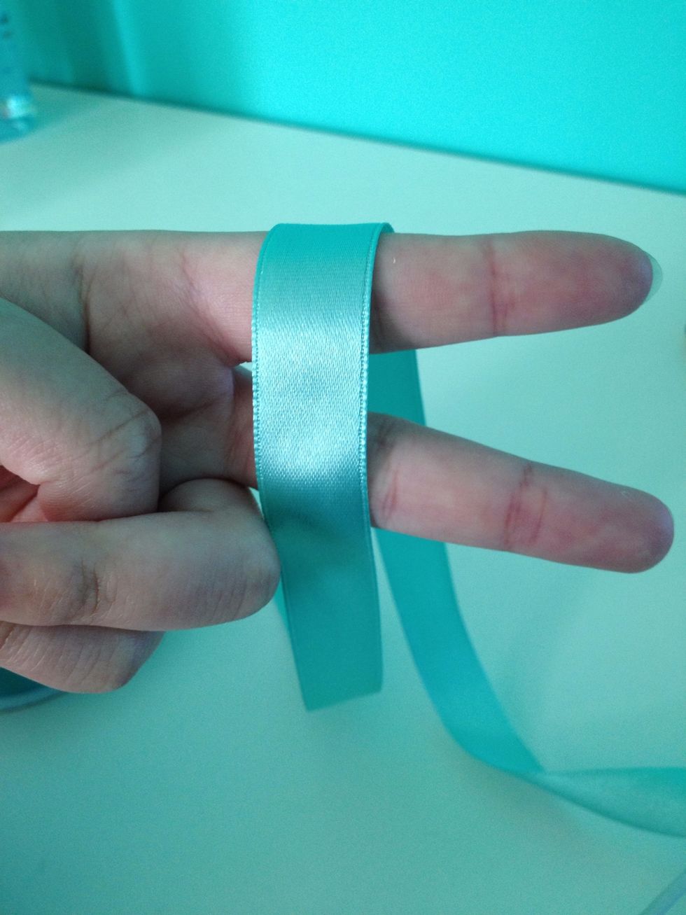 Okay! Wrap the ribbon around two fingers, having one strand in the front and the other at the back.