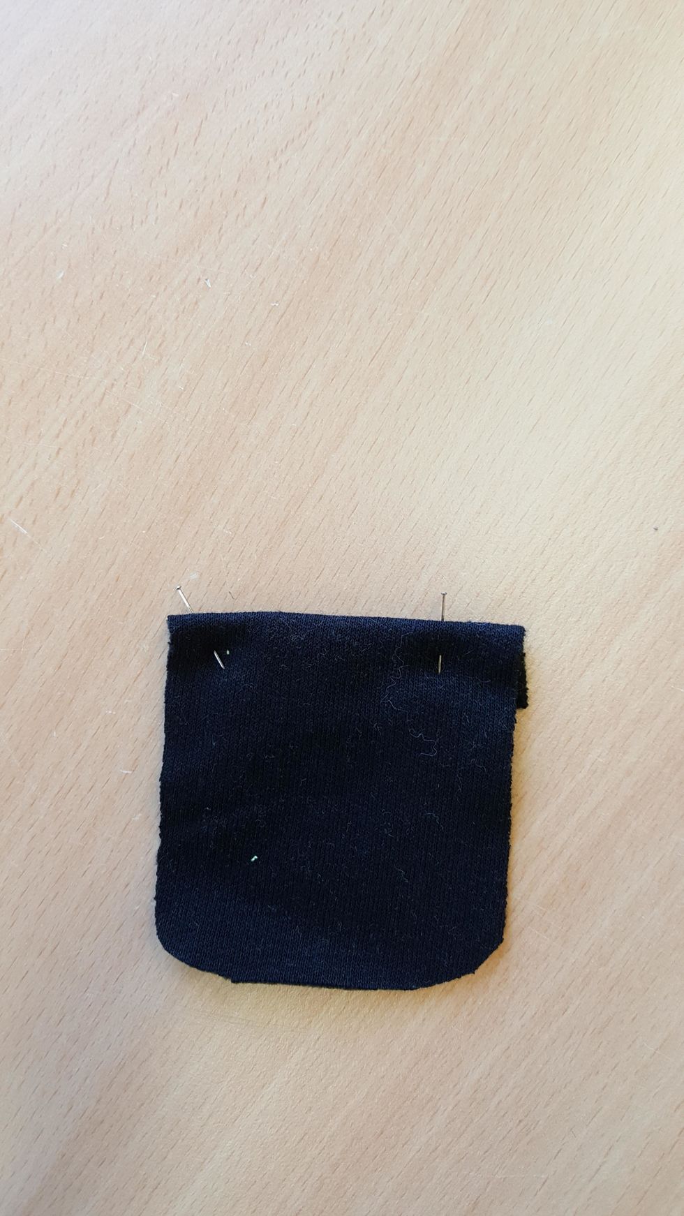 Om du ska ha utanp\u00e5liggande fickor ska dessa sys nu. B\u00f6rja med att vika ner kanten mot avigan och sy fast.