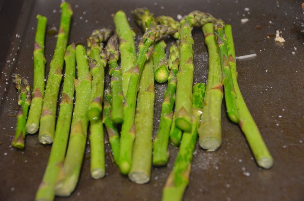 On a baking tray place the asparagus and coat olive oil. Sprinkle salt and black pepper.