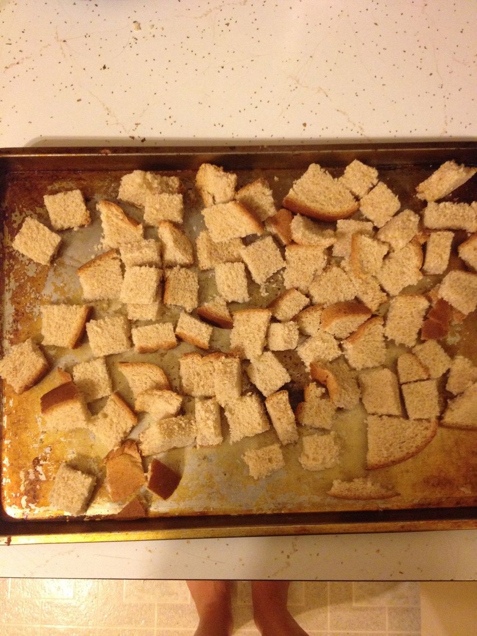 On a large baking sheet, spread out the bread cubes into one layer.