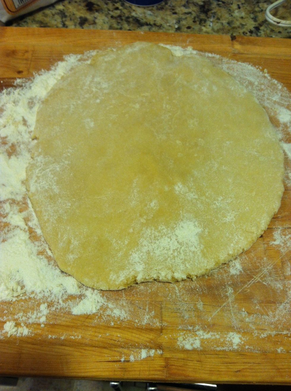 On a lightly floured surface, roll the ball of dough into a circle using your hands or a rolling pin. It should be about 1/3 inch thick.