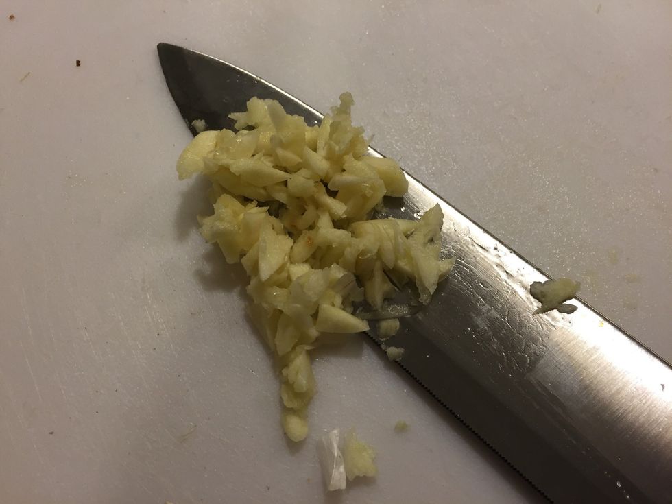 On a new, clean cutting board, chop up your garlic. Don't use the same cutting board you used to cut your chicken up on!