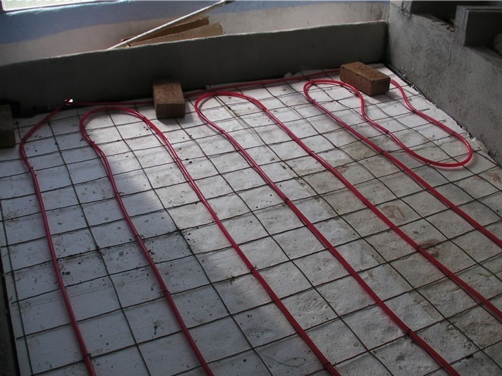 On a sand base, we put sub-floor heating: vapor barrier, sheets of insulation, mesh with PEX pipe attached to it. PEX is connected to a solar water heater. Optional, but warm bricks feel great