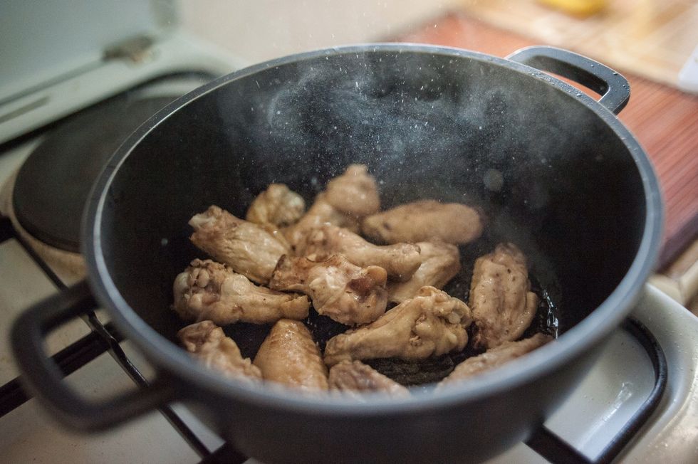 On a very hot pot/pan with little oil, add the chicken wings......