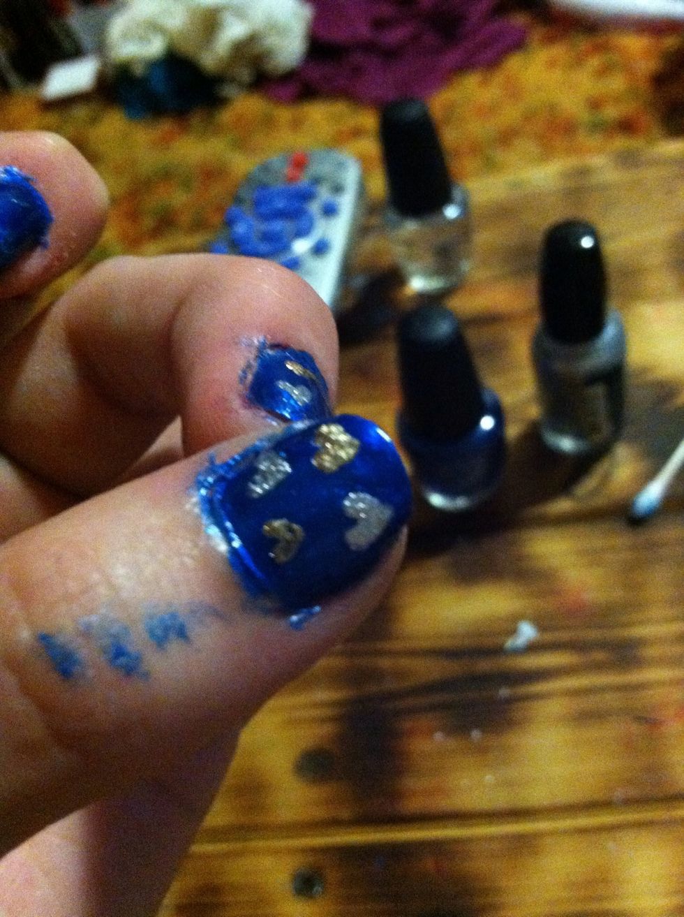 On all of the rest of the nails except for the index, add four hearts. Two silver and two gold.