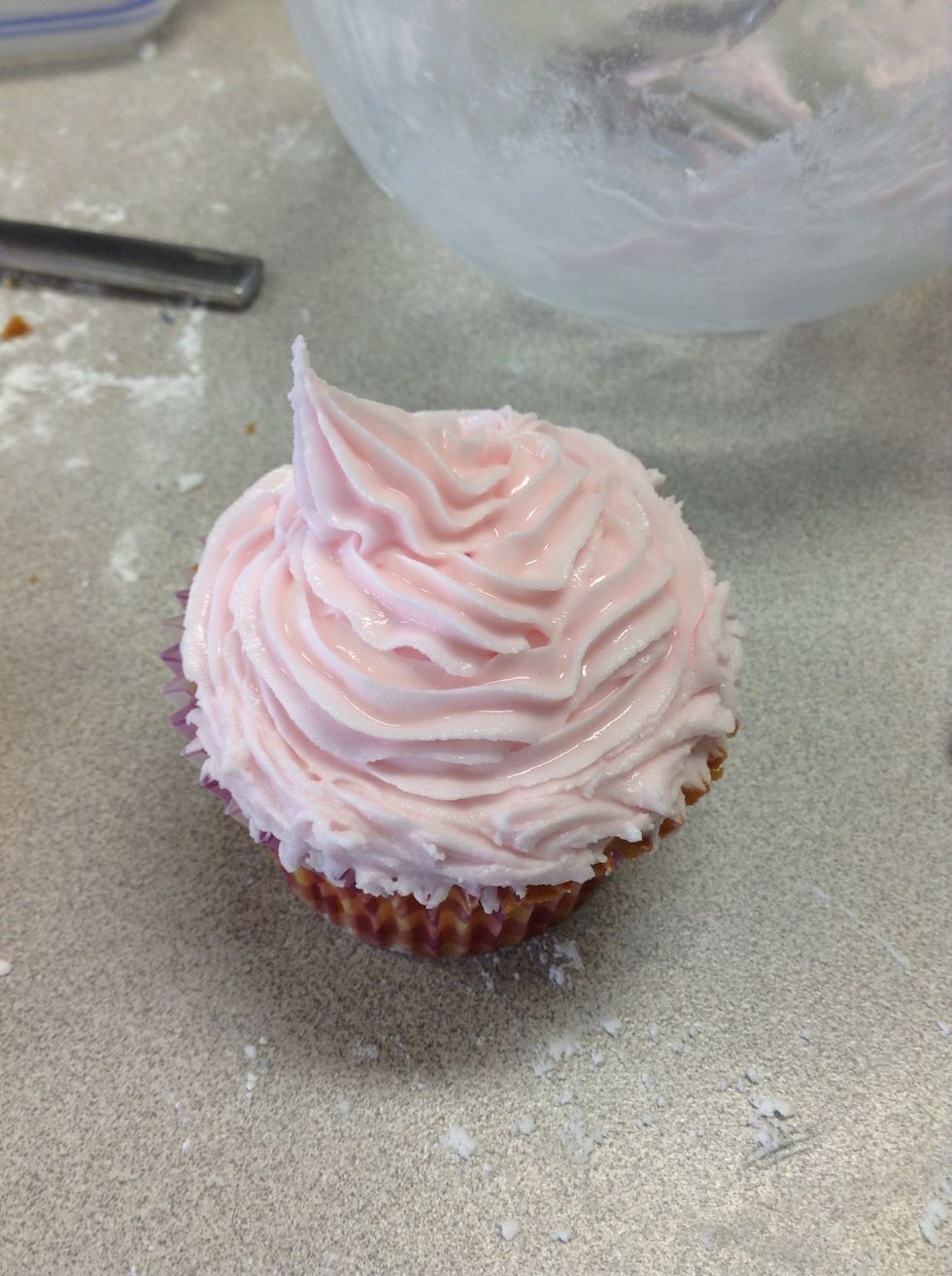 On another cupcake, follow step 19 and add pink food colouring instead of black. Pipe using a bigger star nozzle and pipe around and up until the icing comes to a point like seen above