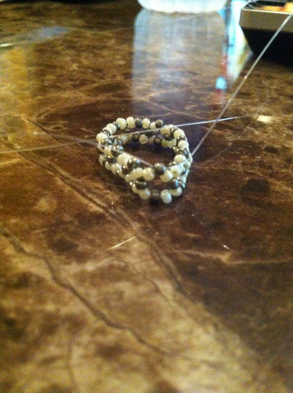 On both cords string a white bead and then 1 silver bead on 1 end and cross through it