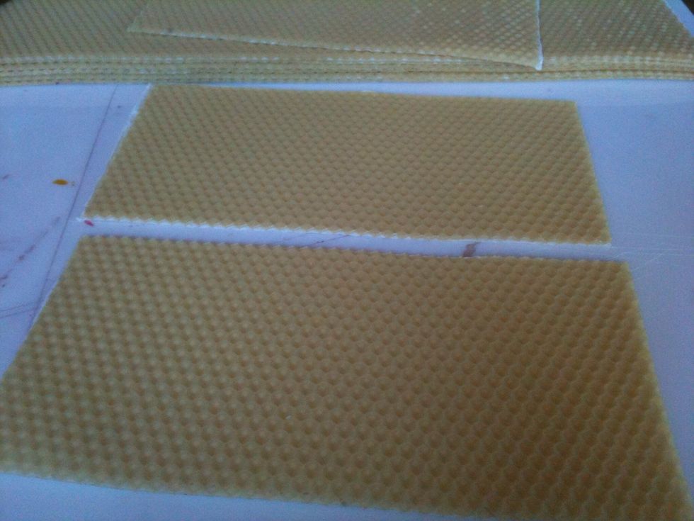 On both pieces, measure the top edges and mark the half way points. Do the same for the bottom edges.  Cut both pieces in half vertically so you have 4 quarters.  You'll need 2 pieces for one candle.