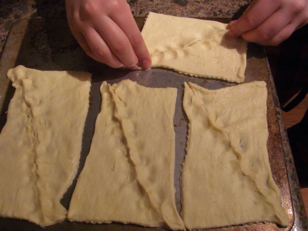 On cookie a sheet, pinch together two crescent roll triangles at the seam, forming rectangles-you should have 4