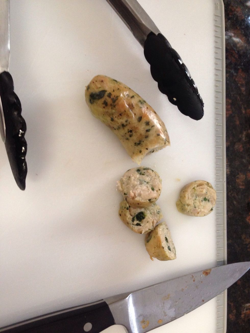 On cutting board with a sharp knife, use your tongs to hold the hot sausage as you slice into rounds.
