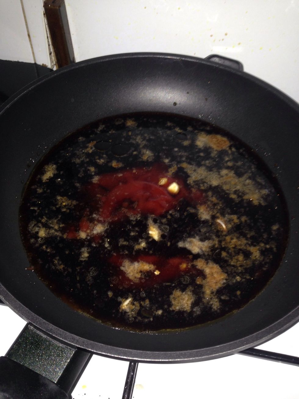 On frying pan, dump in all of the ingredients: garlic, ginger, sesame oil, oyster sauce, soy sauce, honey, tomato ketchup, salt, pepper, & coca cola. Stir well and cook over medium heat