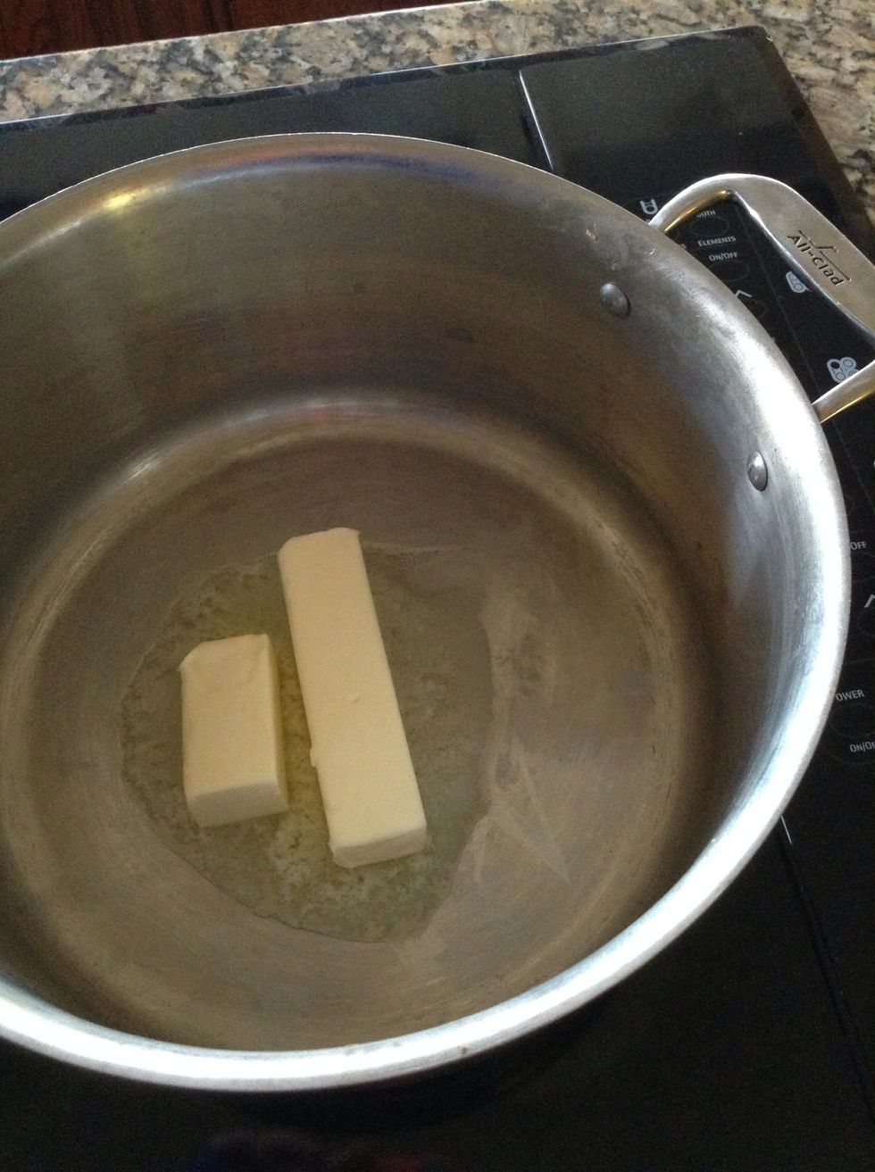 On low heat, and in a large pot; start with a stick and half of butter. Melt somewhat and then add the large marshmallows