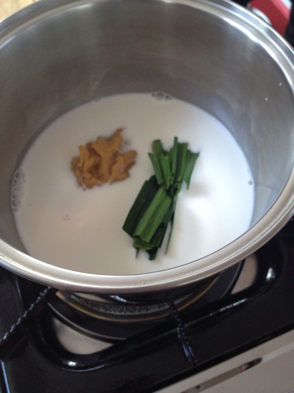 On low heat combine coconut milk and milk. Add palm sugar and pandan leaves (crush the leaves a little first)
