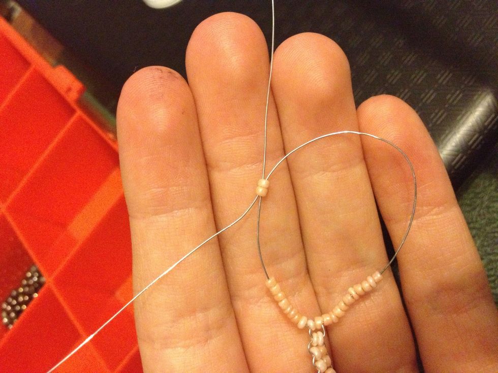 On one side loop one half of the wire through 2 beads on the other side