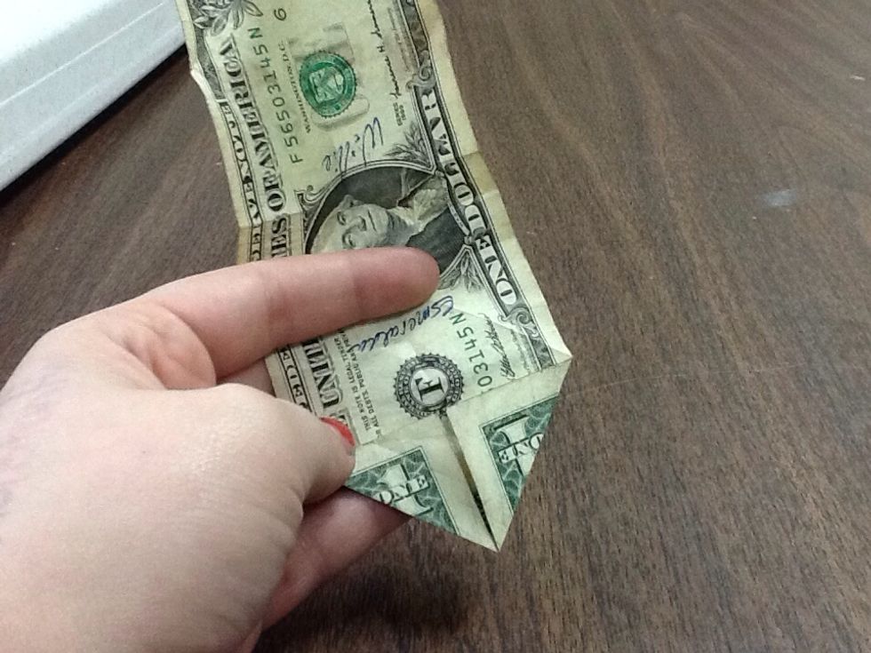 On one side of the opened dollar, fold each corner in to the crease you previously made so that they meet in the middle.