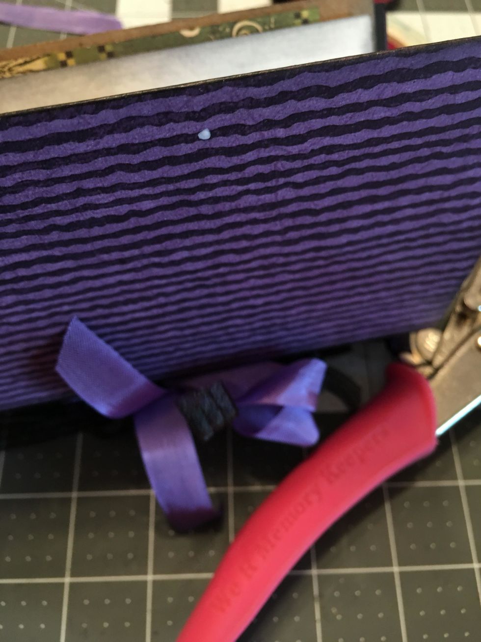 On the back cover of your book, punch a hole on the edge, centered to create a closure.
