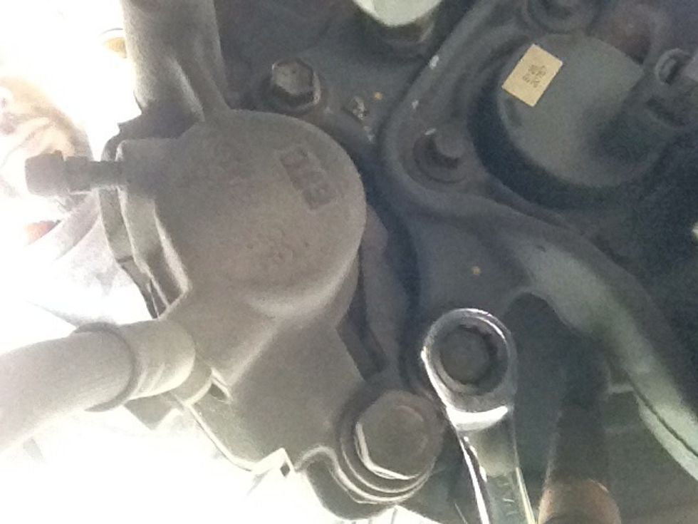 On the back of the caliper, there are 2 14mm bolts, loosen them to remove the caliper