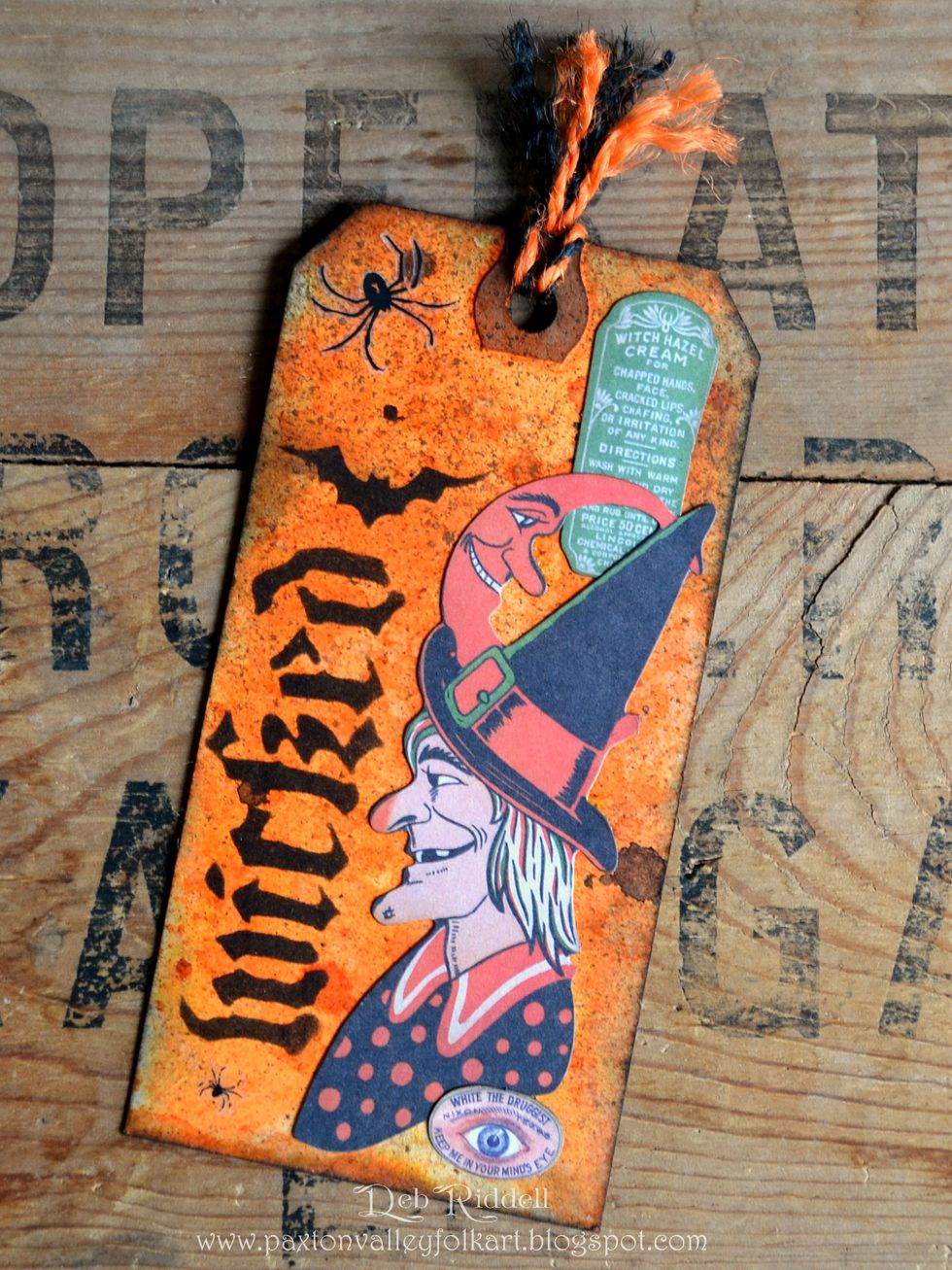 On the back of the same tag, choose elements from the Frightful Ephemera pack and layer. Add another spider from the Curiosities Remnant Rubs.